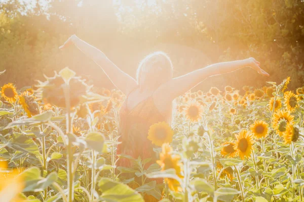 Beauty sunlit woman on yellow sunflower field Freedom and happiness concept — Stock Photo, Image