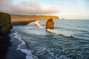 Kirkjufjara plajı ve Arnardrangur uçurumundan gün batımı manzarası. Vik Köyü yakınlarındaki Atlantik Okyanusu, İzlanda.