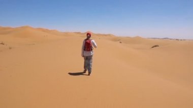 Sportif kadın Sahra çölü boyunca yürüyor