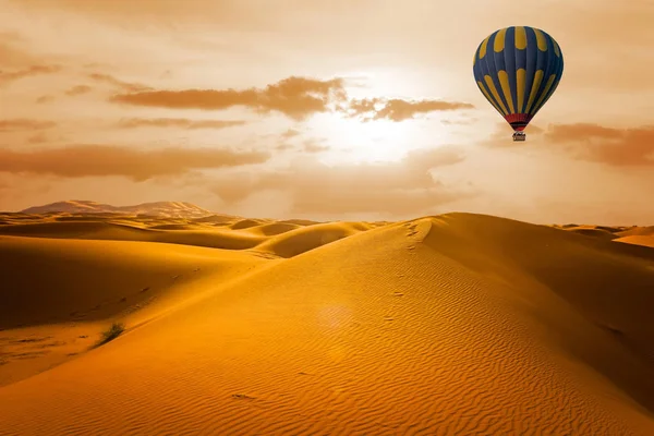 日出时的沙漠和热气球景观 免版税图库图片