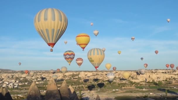 Türkiye 'nin Goreme kentindeki vadilerde bir sürü sıcak hava balonu uçuyor. — Stok video