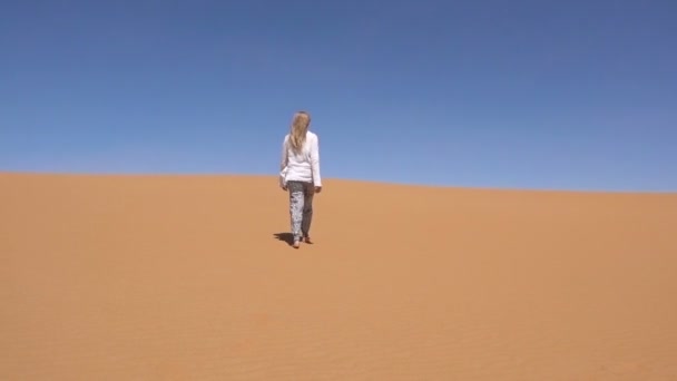 Blond woman walks along Sahara desert — Stock Video