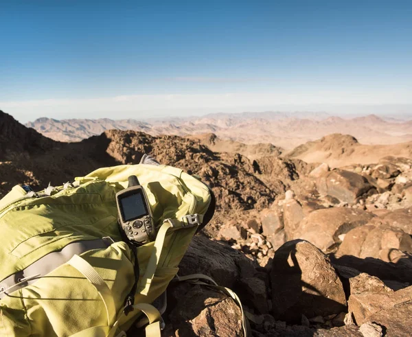 GPS-navigator och ryggsäck bergstopp i öknen — Stockfoto