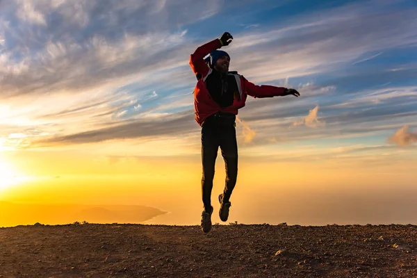 Glücklicher Mann, der vor Freude bei Sonnenuntergang springt. Erfolg, Sieger, Glück, ttavel-Konzept — Stockfoto