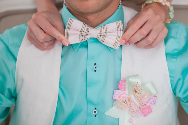Checkered bow tie and boutonniere of ribbons and butterfly.