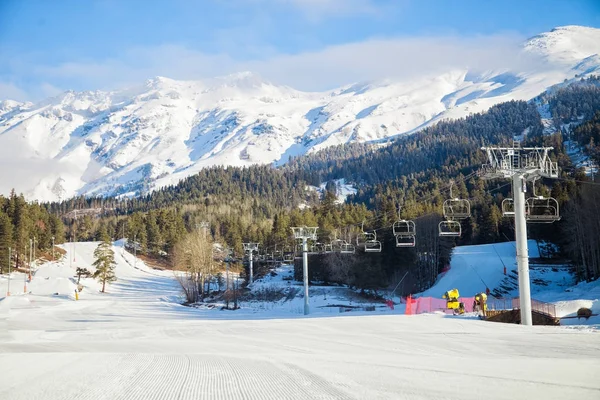 Mañana en la estación de esquí, temporada de invierno. Remonte sobre un fondo de cielo azul y montañas en un día soleado — Foto de Stock