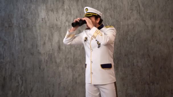白い制服の海の船長は双眼鏡で距離を途中で見て それを下げ 思考では 彼の顔 より軽量な計画をストロークします クルーズ船 — ストック動画