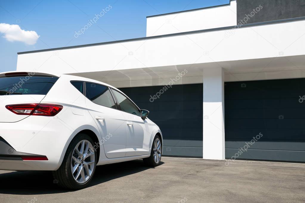 White car in front of modern house