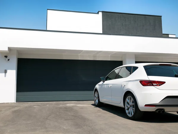 Beyaz araba garajda girmek için bekleyen evin önünde — Stok fotoğraf