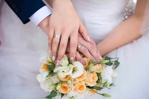 Ruce a prsteny na svatební kytici — Stock fotografie