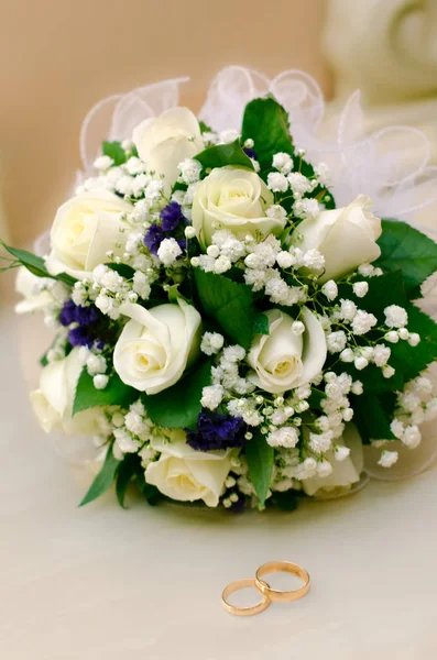 Wedding rings and roses bouquet — Stock Photo, Image