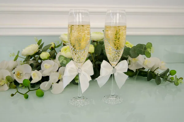 Two glasses filled with champagne, with flowers