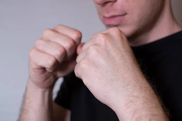 Närbild porträtt av en ung man som står i boxerposition och redo att slåss knyta näven — Stockfoto