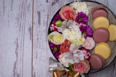 Taze çiçekler ve ahşap arka plan üzerinde macaroons ile kutu