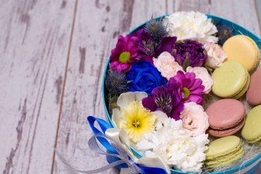 Taze çiçekler ve ahşap arka plan üzerinde macaroons ile kutu