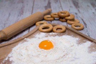 Yumurta sarısı ve beyaz cam kase ve çırpma teli kesme tahtası koyu yıpranmış ahşap masa üzerinde tel