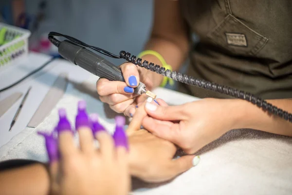 Manicura de ferragens. Remoção de verniz gel antigo no salão. Manicure mestre fazendo procedimento de beleza para o cliente, close-up e vista superior — Fotografia de Stock