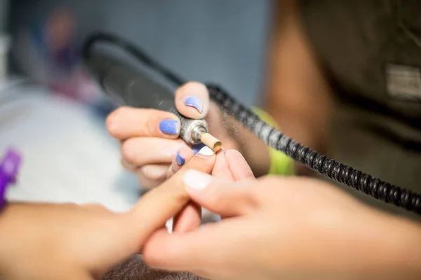 Manicura de ferragens. Remoção de verniz gel antigo no salão. Manicure mestre fazendo procedimento de beleza para o cliente, close-up e vista superior — Fotografia de Stock