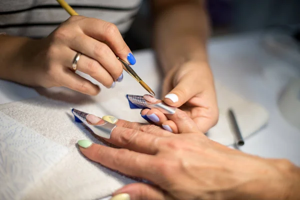 Manicure. Master make nail extension. hands closeup.