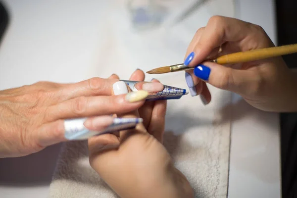 Manicure. Mestre faz extensão de prego. mãos fechadas . — Fotografia de Stock