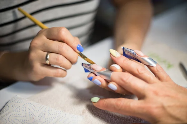 Manicure. Mestre faz extensão de prego. mãos fechadas . — Fotografia de Stock