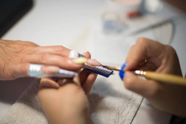 Manicure. Master make nail extension. hands closeup.