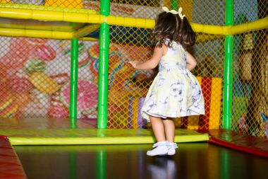 Küçük çocuk, trambolin içinde kapalı Bahçesi atlama. Etkin toddler kız spor merkezinde eğleniyor.