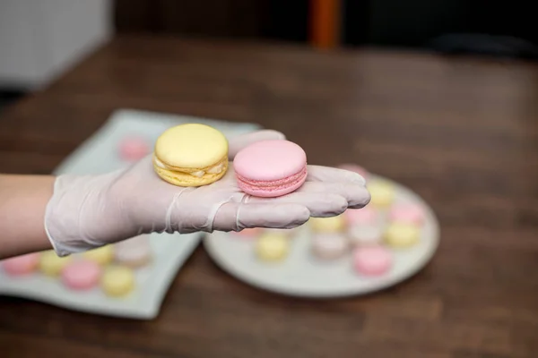 Female hands put together French macaron — Stock Photo, Image