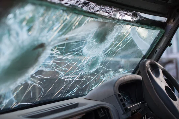 Bullet hole on a car windshield. Car window after a raid has a bullet hole. Broken glass. Bullet holes in a front windshield. Broken Windshield.