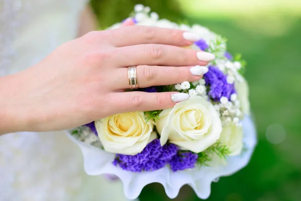 Mains et bagues sur le bouquet de mariage. Thème du mariage — Photo
