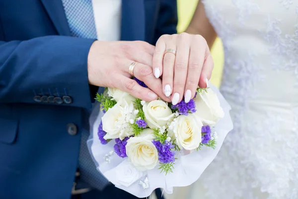 Ruce a prsteny na svatební kytici. svatební motiv — Stock fotografie