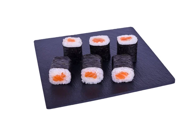Traditionele verse Japanse sushi maki op zwarte steen Maki Syake op een witte achtergrond. Roll ingrediënten: zalm, nori, rijst. — Stockfoto