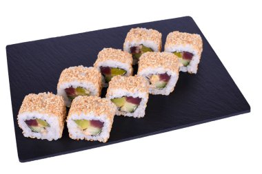 Geleneksel taze Japon suşisi beyaz arka planda Theca Baharatı üzerinde siyah bir taş üzerinde yuvarlanır. Sarma malzemeleri: ton balığı, daikon turpu, salatalık, baharat sosu, nori, pilav, beyaz susam tohumu.