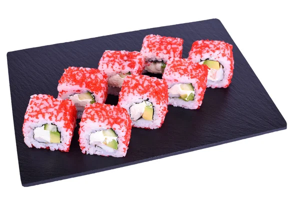 Geleneksel taze Japon suşisi beyaz arka planda siyah taştan bir Kaliforniya ebi 'sinde yuvarlanıyor. Sarma malzemeleri: kaplan karidesi, Philadelphia peyniri, avokado, kırmızı tobiko havyarı, nori, pilav.