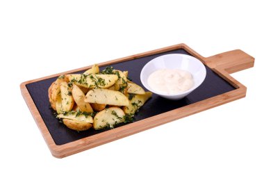 Ahşap bir tahtanın üzerinde kızartılmış patates dilimleri, otlar ve sarımsak sosu. beyaz arkaplanda izole edilmiş