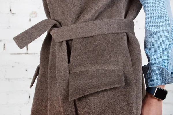 Belt and coat pocket close-up