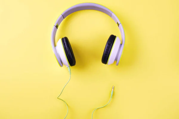 Light green headphones on a yellow background