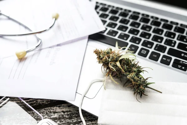 Medical marijuana on the doctor table - medical records, laptop, stethoscope, mask