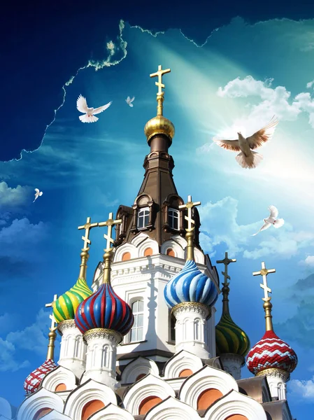 Kościół prawosławny na niebieskim tle nieba, a promienie słońca gołębie latające na niebie. — Zdjęcie stockowe