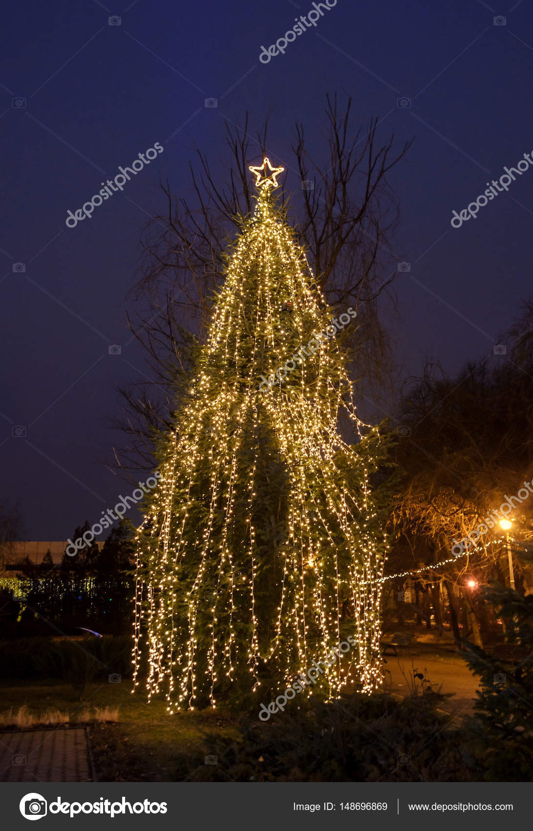 Gekleurde verlichte kerstboom met ornamenten, buiten nachttijd ... Gekleurde verlichte kerstboom met ornamenten, buiten nachttijd ...