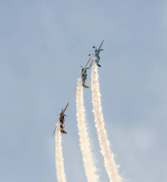 Pilotos acrobáticos con sus aviones de color entrenando en el azul —  Fotos de Stock