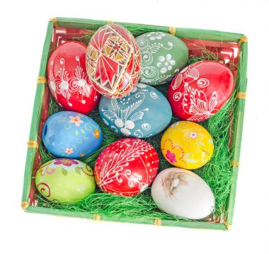 Yeşil çim ile sepetteki renkli geleneksel Paskalya yumurtaları