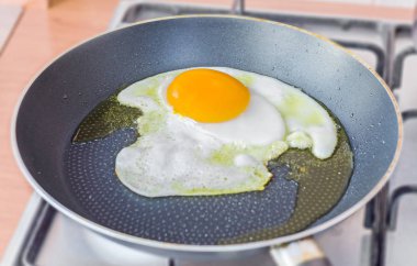 Kaz büyük yumurta zeytin yağı bir tavada kızarmış, yakın çekim, izole.