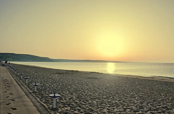 Salida del sol en la playa, arena y aguas cristalinas, la orilla del Mar Negro — Foto de Stock