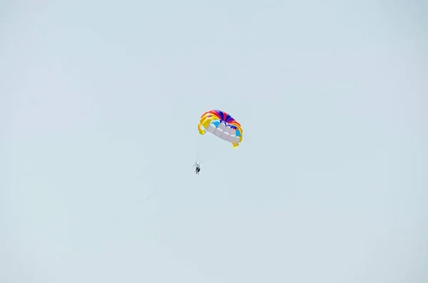 Цветное крыло парашютиста в голубом небе, парасейлинг — стоковое фото