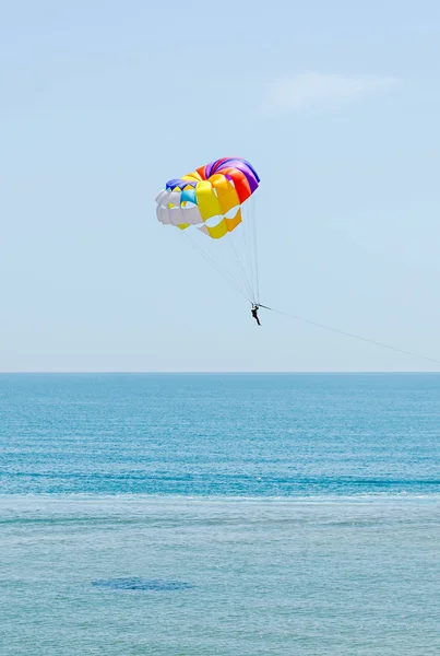 Цветное крыло парашютиста в голубом небе, парасейлинг — стоковое фото