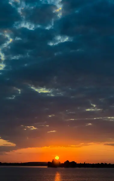 Pôr-do-sol laranja sobre um lago europeu, céu azul nuvens, colorido dramático — Fotografia de Stock