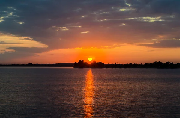 Pôr-do-sol laranja sobre um lago europeu, céu azul nuvens, colorido dramático — Fotografia de Stock