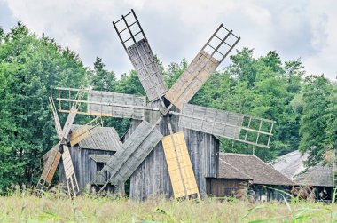 Yel değirmenleri, yeşil orman, vahşi bitki örtüsü kapatın, bulutlar gökyüzü mavi