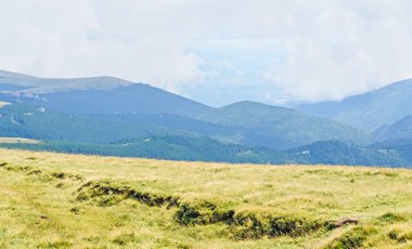 Bulutlar, yeşil çim ve kayalar ile hills Parang dağlarda